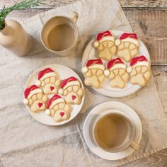 two plates with cookies decorated like teddy bears next to a cup of coffee