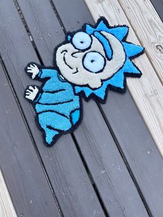 a blue rug with an image of a cartoon character is on a wooden floor next to a piece of wood