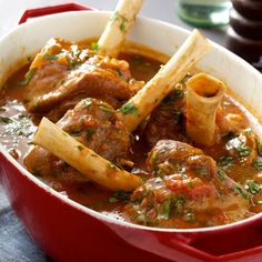 a red pot filled with meat and pasta