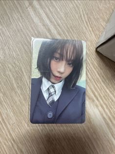 a photo of a woman wearing a suit and tie on a wooden table next to a computer mouse