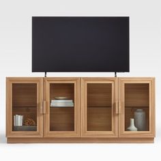 a wooden entertainment center with glass doors and black screen on the top, in front of a white background