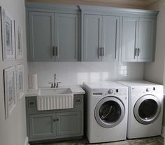 a washer and dryer in a small room next to a window with pictures on the wall