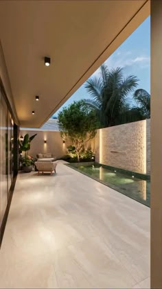 an indoor swimming pool in the middle of a large house with trees and plants on either side