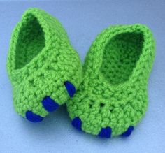 a pair of green crocheted shoes with blue feet