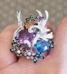 A beautiful big cluster multi color stones ring18 pieces Pink tourmaline weight 0.70 carat. 9 pieces of topaz weight 2.60 carats. 2 stones ( amethyst, citrine) total weight 6.60 Carats. 15 green garnets total weight 0.20 carat. 119 pieces of diamonds total weight 0.60 carats. 18kt White gold ring setting 14.50 grams. Colored Stone Rings, Green Garnet, Color Stones, Contemporary Ring, Ring Setting, White Gold Ring, Rose Gold Diamonds, Amethyst Gemstone, Cluster Ring