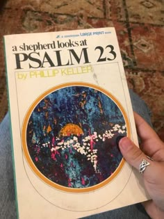 a person holding up a book with the title, a shepherd looks at psalm 23