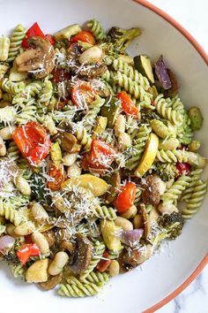 a white bowl filled with pasta and vegetables