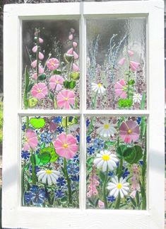 a window with flowers painted on it and glass in the windows panes is shown