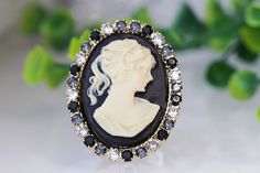 BLACK CAMEO RING, Vintage Cocktail Ring, Black White Ring, Statement Ring, Antique Style Ring, Lady Cameo Ring, Eco Friendly GifT . Details of item: Metal: Gold plated, silver plated, rose gold plated or brass antique plated Gemstone: acrylic cameo and around the cameo is crystal Front Size: 25*18 mm The ring will be packed in a gift box. , FOR MY RINGS COLLECTION HERE: https://www.etsy.com/il-en/shop/rebekajewelry?ref=seller-platform-mcnav&section_id=14282915 TO GET TO MY ETSY SHOP: https:/ Vintage Black Cameo Ring, Black Round Cameo Jewelry, Black Cameo Ring As Gift, Black Cameo Ring For Gift, White Opal Bracelet, Black Cameo, White Opal Earrings, Antique Style Rings, Vintage Cocktail Ring