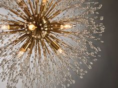 a chandelier with many lights hanging from it's center point, in the shape of a starburst