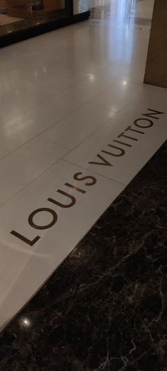 the louis vuitton sign is on the floor at the entrance to the building