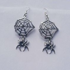 This listing is for one pair of Hanging Spider Web Dangle Earrings. Web and Spider charms measure approximately 44mm long and are attached to lead/nickel free silver toned hooks. Earrings come in a colorful organza pouch. Gift box may be purchased if sending as a gift. May also include a note to recipient if desired (no extra charge). Witchy Style Pierced Earrings As Gift, Pierced Witchy Earrings For Gift, Witchy Style Pierced Earrings For Gift, Witchy Pierced Earrings As Gift, Themed Dangle Pierced Earrings, Halloween Themed Dangle Jewelry, Halloween Plug Earrings As Gift, Halloween Novelty Drop Earrings Jewelry, Novelty Drop Earrings For Halloween