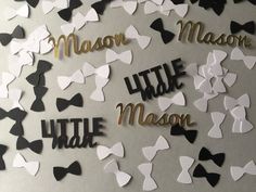 paper cutouts that say little man and little woman with bow ties on them in gold, black, and white