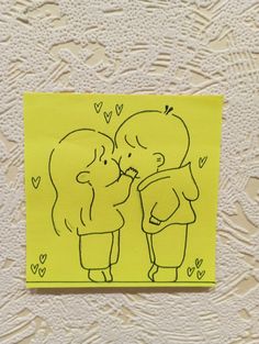 a drawing of two people kissing each other on a yellow piece of paper with hearts