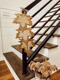 a plant in a pot sitting on top of a wooden table next to a stair case