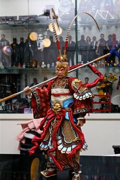 a statue of a woman with two swords in her hand and wearing an elaborate costume