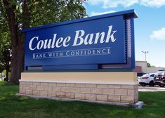 a large sign for a bank in front of some parked cars