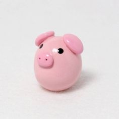 a pink pig toy sitting on top of a white surface