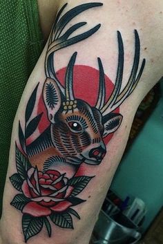 a deer with antlers and roses on his arm