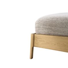 an upholstered bed with wooden frame and foot board in front of a white background