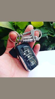 a hand holding a key chain with a car keychain attached to it,