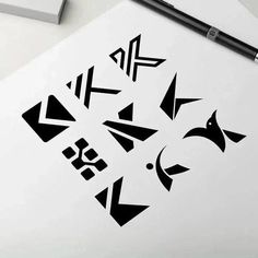 an image of some black and white designs on a piece of paper next to a pen