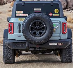 the back end of a blue jeep with stickers on it