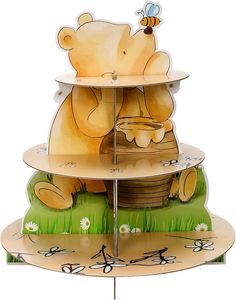 a three tiered cake stand with a bear and bee design on the top, holding a honey pot