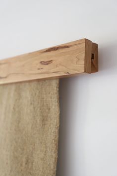 a piece of wood is hanging on the wall next to a towel rack with hooks