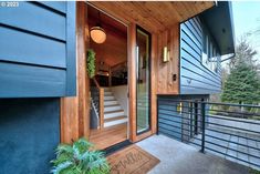 the front door of a house with stairs leading up to it's second story