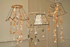 three lamps hanging from the ceiling with leaves on them