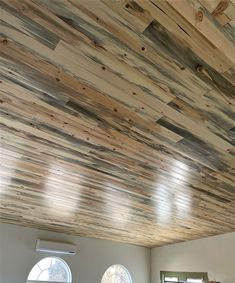 a living room filled with lots of furniture and wooden walls covered in wood planks