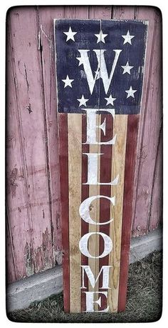 a wooden sign that says welcome home with an american flag painted on the side of it