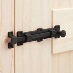 a close up of a door handle on a wooden door with black iron handles and knobs