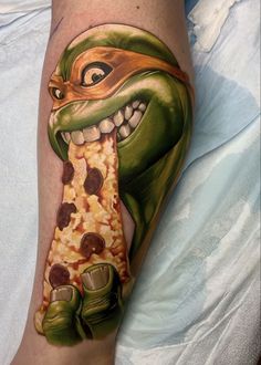 a close up of a person's leg with a tattoo on it and a piece of pizza in the shape of a snake