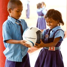 two children holding a soccer ball in their hands