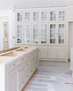 a large kitchen with white cabinets and drawers