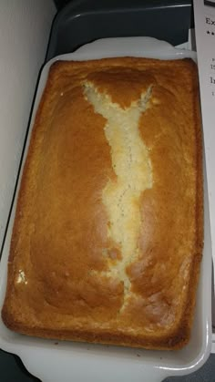 a loaf of bread sitting on top of a white tray next to a piece of paper