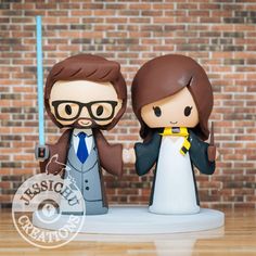 a star wars bride and groom cake topper with lightsaben on the side