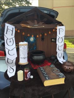 the trunk of a car is decorated with signs and books, candles, and other items