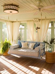 the sun shines through the windows onto a porch with couches and potted plants