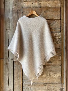 Beige lambswool poncho cape with fringes Ladies poncho cape BEIGE Pure wool hooded ladies ponchos Sand beige pure wool blanket poncho cape One size fits fashionably for most everyone, short or tall, big or small. This piece is versatile for both Men's & Women's outdoor fashion, and can be used insider in cooler winter weather to keep warm while reading on the couch. CARE: Hand-wash and hang to dry, light iron if needed, or dry clean. MEASURES: Length at the front of the neckline to the bottom is Beige Alpaca Shawl Poncho, Beige Fringed Poncho Shawl, Beige Fringe Shawl Poncho, Beige Alpaca Poncho For Winter, Winter Beige Alpaca Poncho, Cozy Beige Wool Poncho, Beige Fringed Shawl For Winter, Beige Fringed Winter Shawl, Winter Beige Fringe Shawl