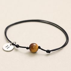 This handmade bracelet made of black textile features a tiger eye bead, which represents strength and energy. The simple but powerful stone is securely fastened with two knots and makes the bracelet a special companion in everyday life. Tiger's eye is known for its protective properties and strengthens inner strength and self-confidence. The bracelet is individually adjustable in length and is easy to put on, making it both a stylish accessory and an ideal gift for your loved one. This bracelet Minimalist Adjustable Bracelets For Meditation, Adjustable Minimalist Bracelets For Meditation, Minimalist Adjustable Bracelet For Meditation, Adjustable Personalized Bracelets, Adjustable Personalized Bracelets For Meditation, Energy Bracelets, Tiger Eye Beads, Protection Bracelet, Tiger's Eye