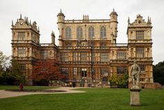 a large building with many windows and statues in front of it on a cloudy day