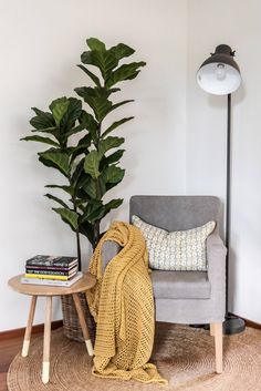 a living room with a couch, chair and potted plant on the side table