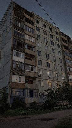 an apartment building with balconies on the top floor and lots of windows at night