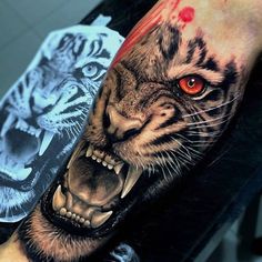 a man with a tiger tattoo on his arm next to another person's leg