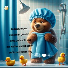 a teddy bear with a blue towel and rubber ducks