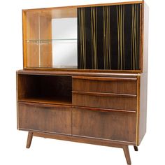 a wooden dresser with a mirror on top of it next to a wall mounted shelf