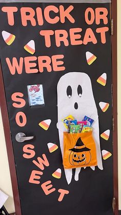 a door decorated for halloween with a trick or treat bag and candy in the shape of a ghost